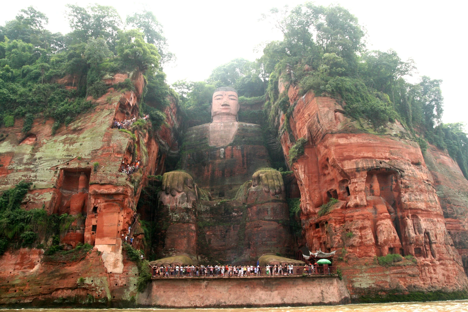 The complete seated Leshan Giant Buddha carved into a red sandstone cliff