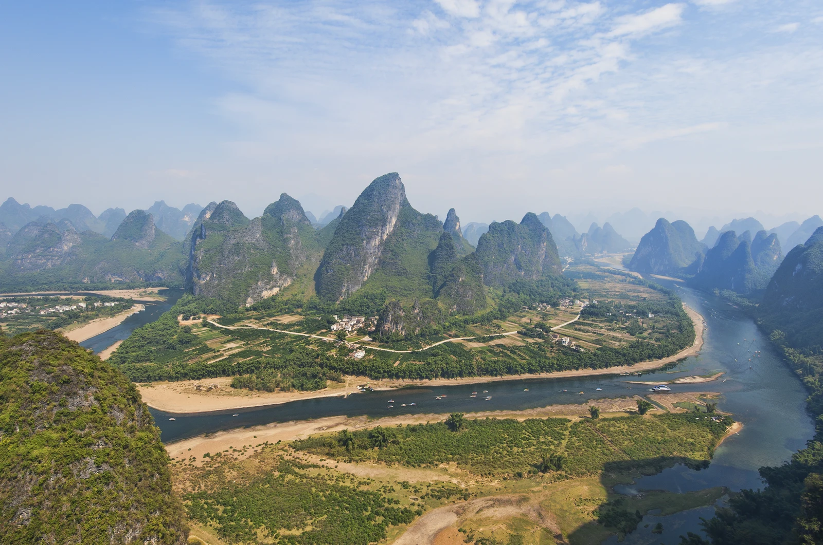 The Li River curves between green karst peaks and fields near Yangshuo