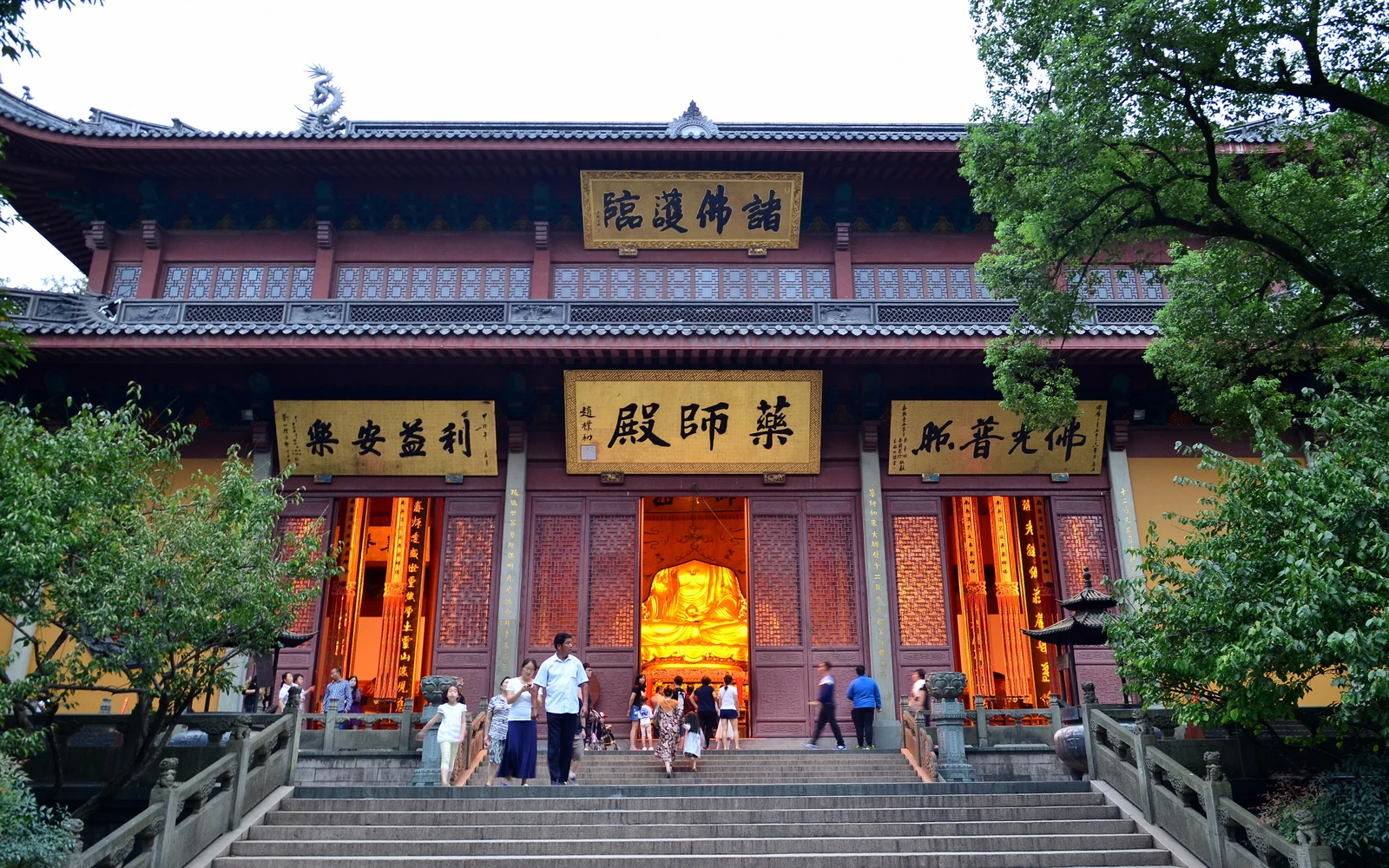 The main hall of Lingyin Temple framed by leafy trees in Hangzhou