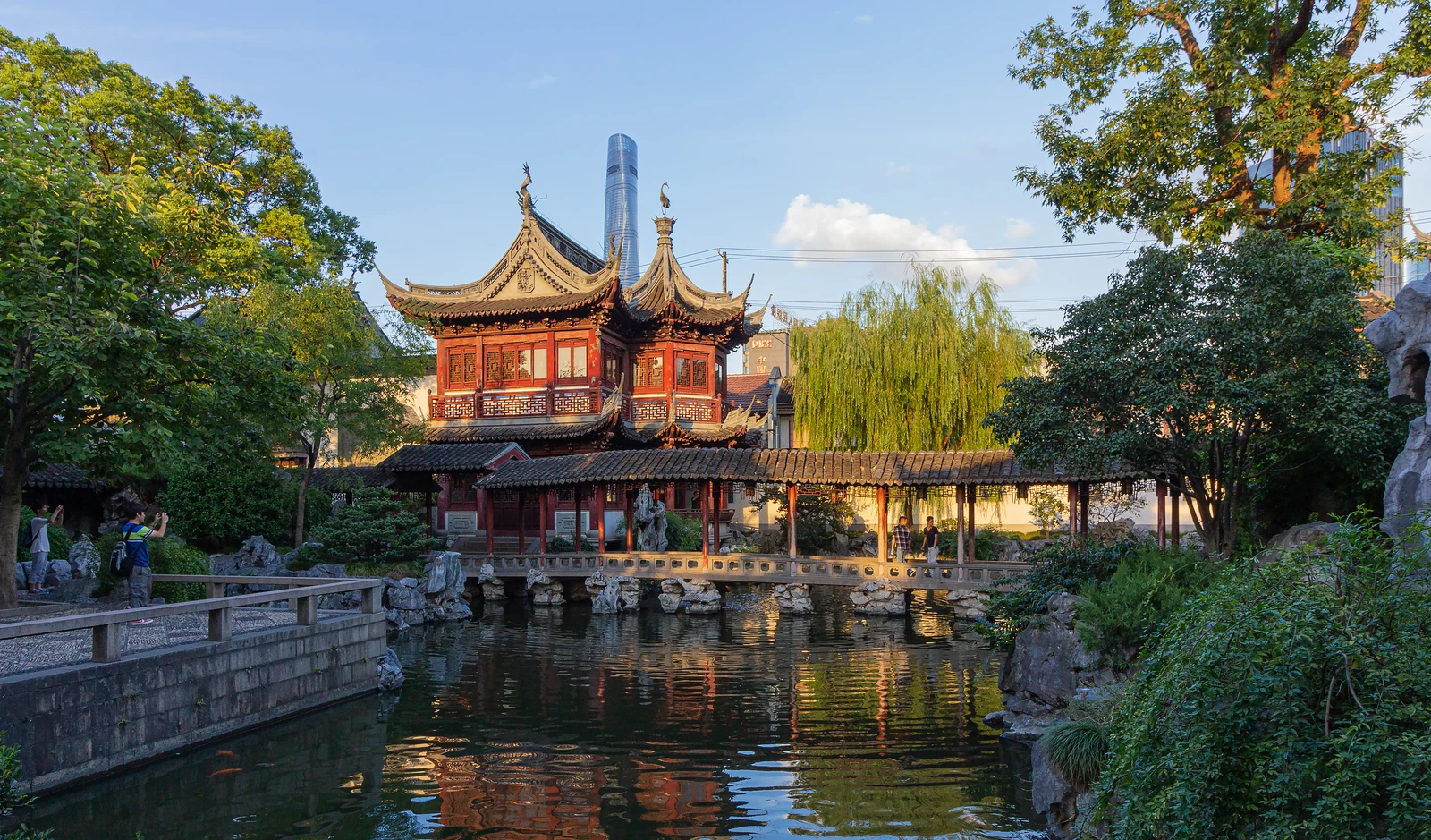 A golden pavilion, covered walkway and reflections in Shanghai Yu Garden