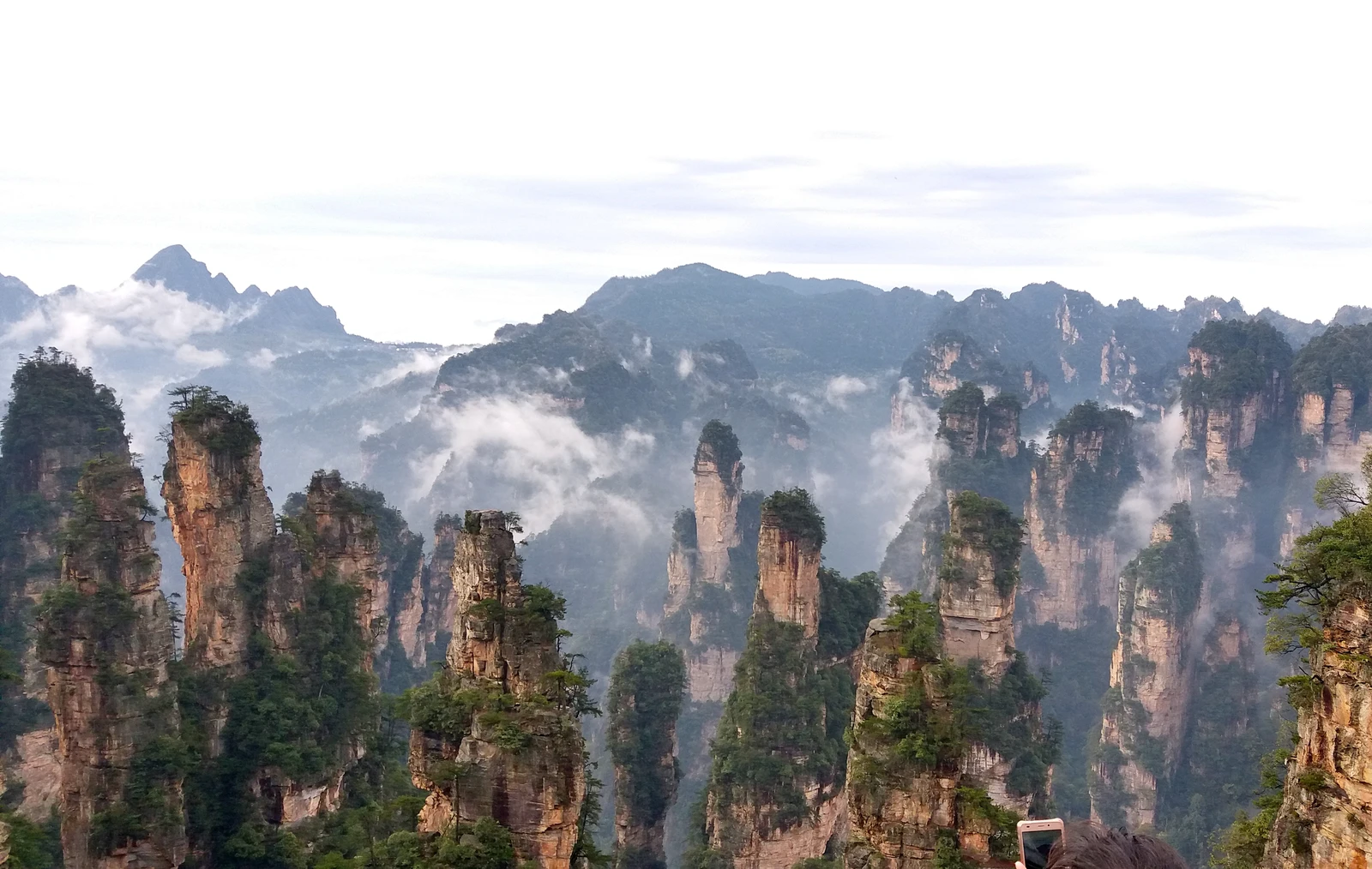 Morning cloud drifts between the dramatic sandstone pillars of Wulingyuan