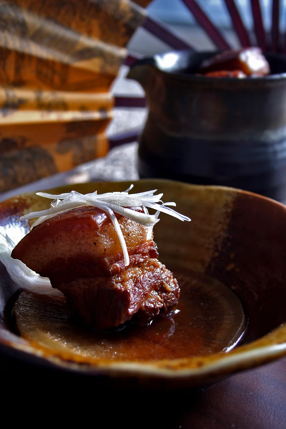 A glossy cube of Dongpo braised pork belly in a shallow bowl