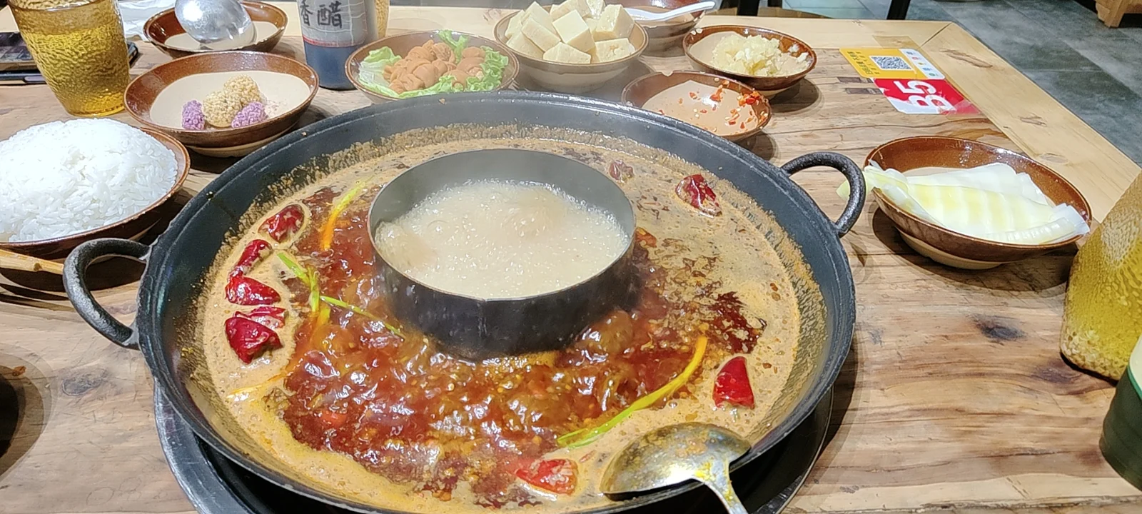 Sichuan hotpot bubbling with dried chilies and side dishes